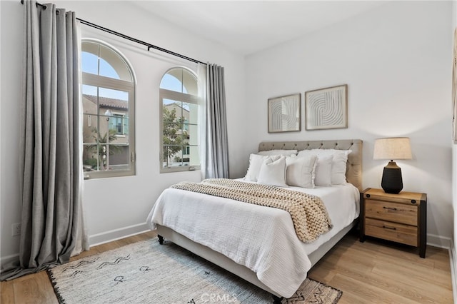 bedroom featuring light wood-type flooring and baseboards