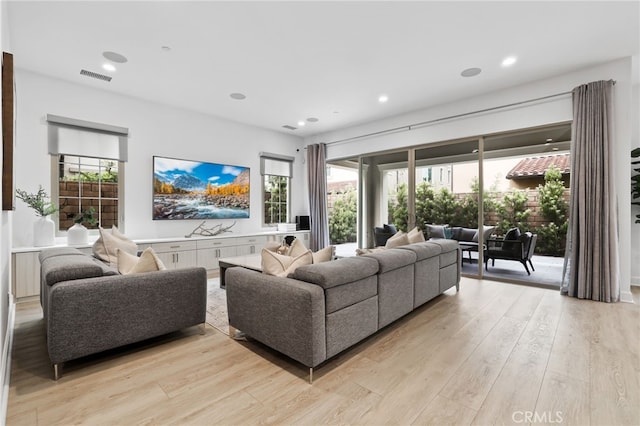 living area with recessed lighting, light wood-style floors, visible vents, and a healthy amount of sunlight