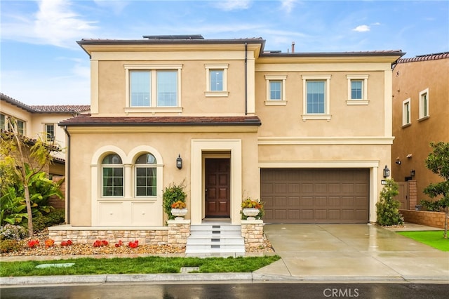 view of front of home featuring stucco siding, concrete driveway, and an attached garage