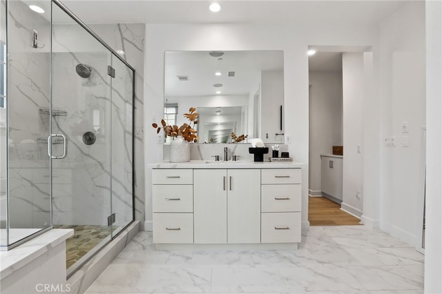 bathroom featuring a marble finish shower, marble finish floor, and vanity