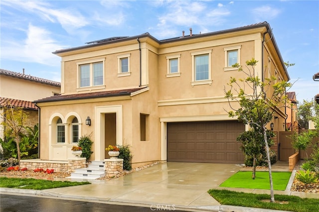 view of front of home featuring stucco siding, an attached garage, concrete driveway, and fence