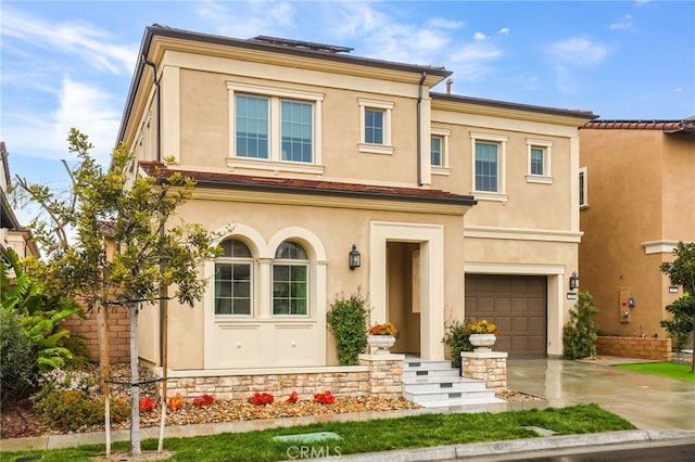 view of front of property with stucco siding, an attached garage, and concrete driveway