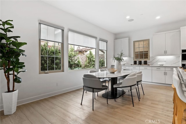 dining space featuring light wood-style flooring, recessed lighting, and baseboards