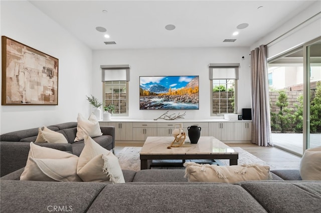 living room with recessed lighting, visible vents, and light wood-style flooring