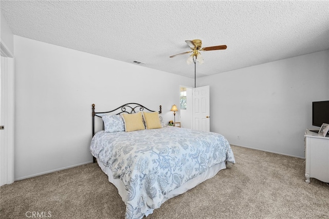 carpeted bedroom featuring visible vents, a textured ceiling, and a ceiling fan