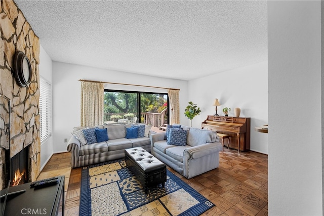 living area with parquet floors, a fireplace, and a textured ceiling