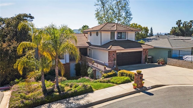 view of front facade with brick siding, concrete driveway, an attached garage, and a tiled roof