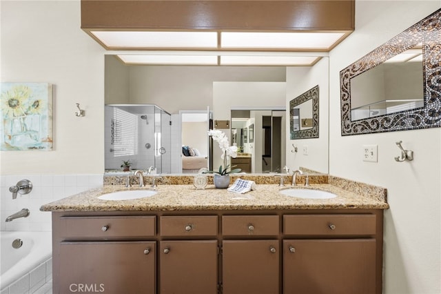 full bathroom featuring double vanity, a shower stall, and a sink