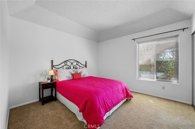 carpeted bedroom with a textured ceiling and baseboards