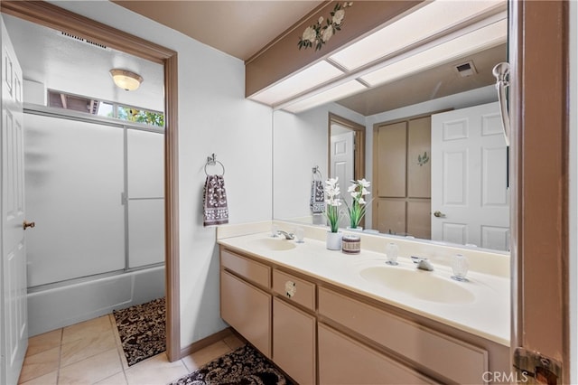 bathroom with a sink, visible vents, double vanity, and tile patterned flooring