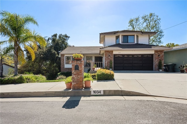 traditional-style home featuring brick siding, driveway, and an attached garage