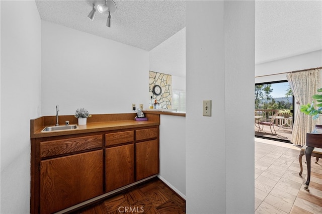 interior space featuring a textured ceiling, baseboards, and a sink