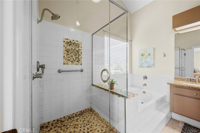 full bathroom with a shower stall, vanity, and a garden tub