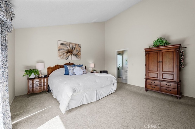 bedroom with lofted ceiling, ensuite bathroom, and light carpet