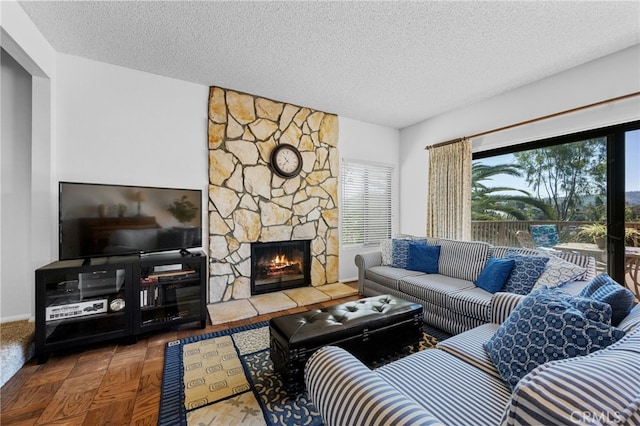 living room featuring a stone fireplace and a textured ceiling