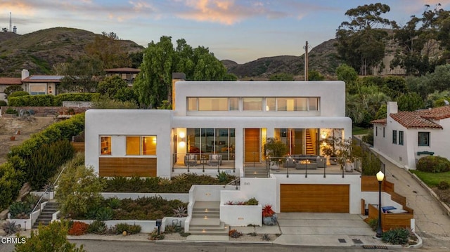 view of front of home with a mountain view, stairway, and stucco siding