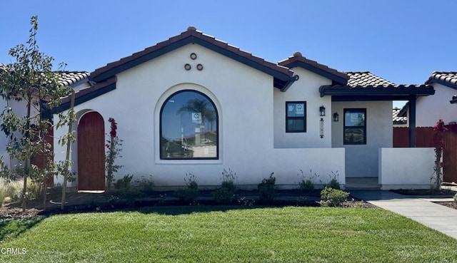 1160 W First St, Oxnard, CA 93030 - mediterranean / spanish home with a front yard, fence, a tiled roof, and stucco siding