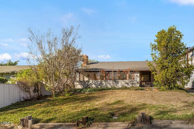 back of house with fence and a yard