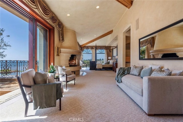 living area featuring carpet floors, a healthy amount of sunlight, a fireplace, and beam ceiling