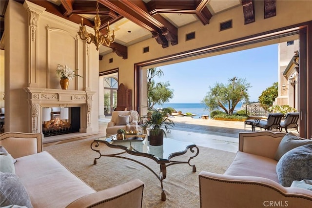 living area with a chandelier, coffered ceiling, a water view, a multi sided fireplace, and beam ceiling