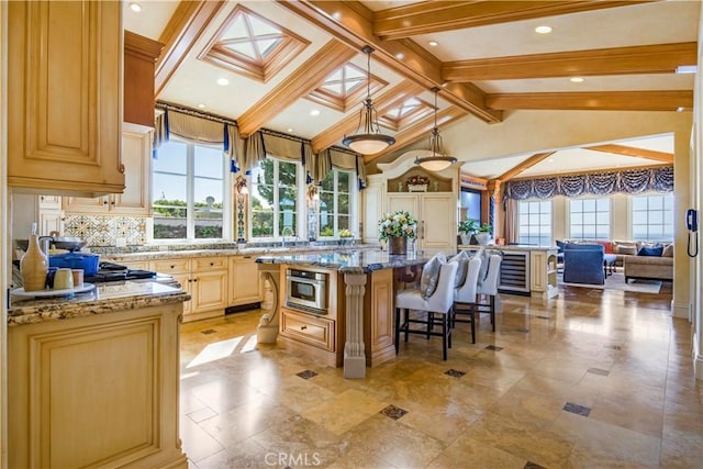 kitchen featuring a healthy amount of sunlight, lofted ceiling with skylight, a kitchen island, and a kitchen breakfast bar