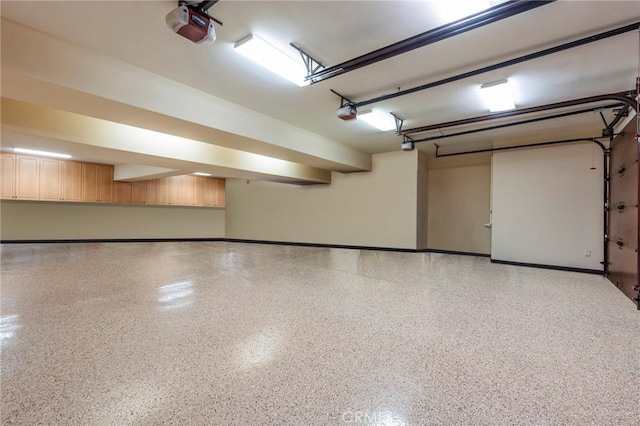 garage with baseboards and a garage door opener