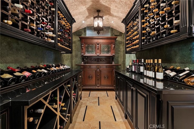 wine room featuring lofted ceiling and brick ceiling