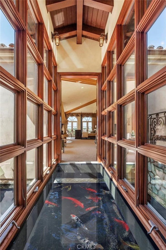 hall with marble finish floor and vaulted ceiling with beams