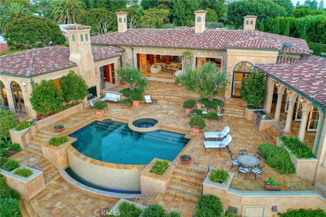 view of swimming pool featuring an in ground hot tub and a patio