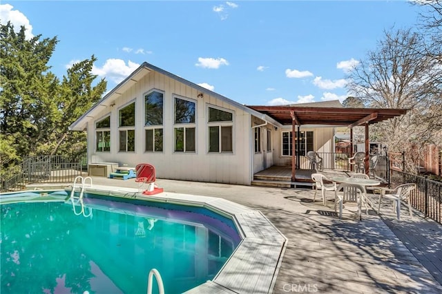 rear view of property featuring fence, a deck, and a fenced in pool