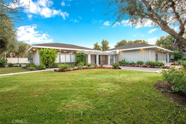 view of front of property with a front yard and a pergola