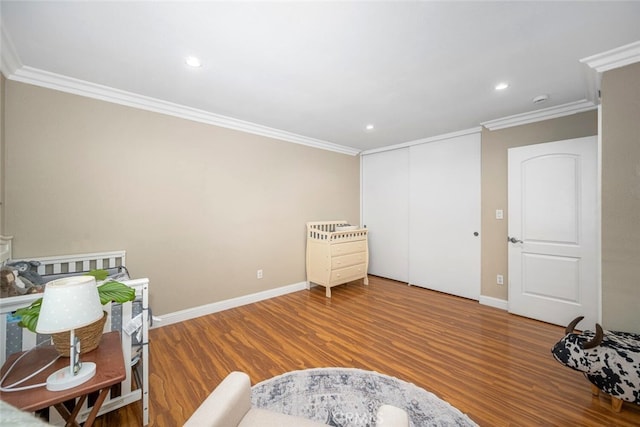 living area featuring ornamental molding, wood finished floors, and baseboards