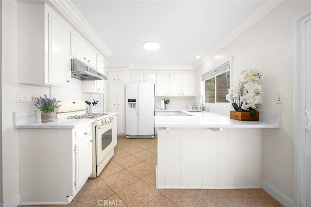 kitchen with white appliances, under cabinet range hood, light countertops, white cabinets, and a peninsula