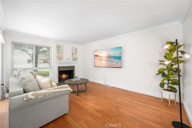 living room with ornamental molding, wood finished floors, and baseboards