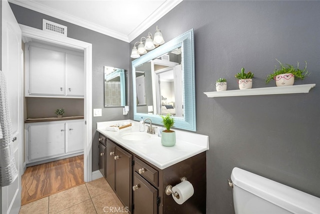 half bath featuring crown molding, visible vents, toilet, vanity, and tile patterned flooring