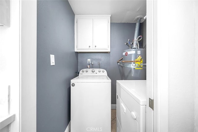 laundry area with washing machine and dryer, tile patterned flooring, cabinet space, and water heater