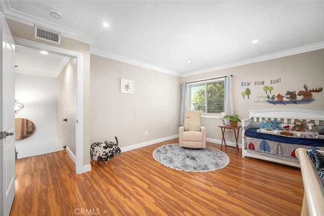 living area featuring ornamental molding, visible vents, wood finished floors, and baseboards