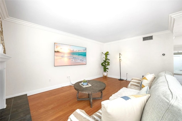 living area with wood finished floors, visible vents, crown molding, and baseboards