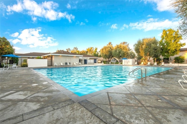 pool with fence and a patio area