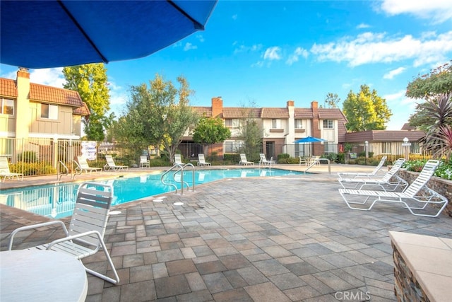 pool featuring fence and a patio area