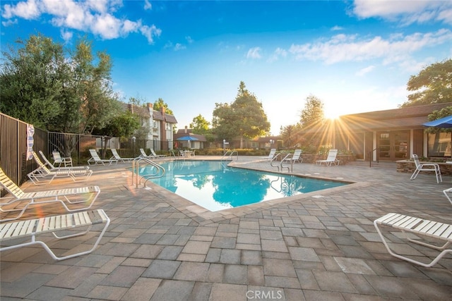 pool with fence, a patio area, and french doors