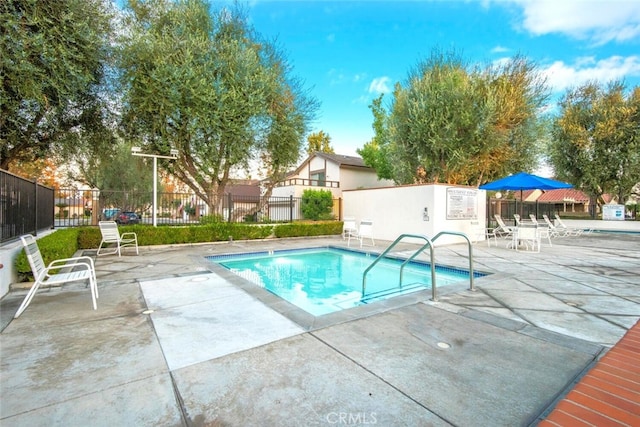 view of swimming pool with fence, a swimming pool, and a patio area