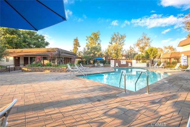 pool featuring fence and a patio area