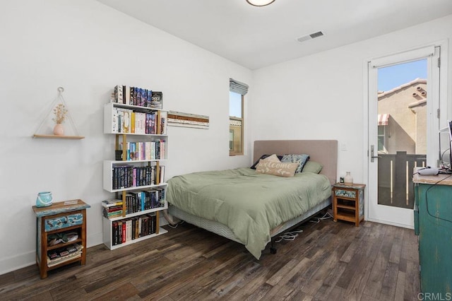 bedroom featuring baseboards, visible vents, and wood finished floors