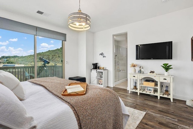 bedroom with wood finished floors, visible vents, baseboards, access to exterior, and ensuite bath