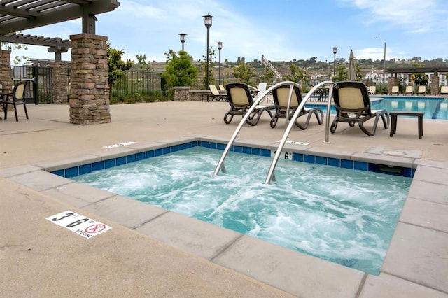 pool featuring a community hot tub, a patio area, fence, and a pergola