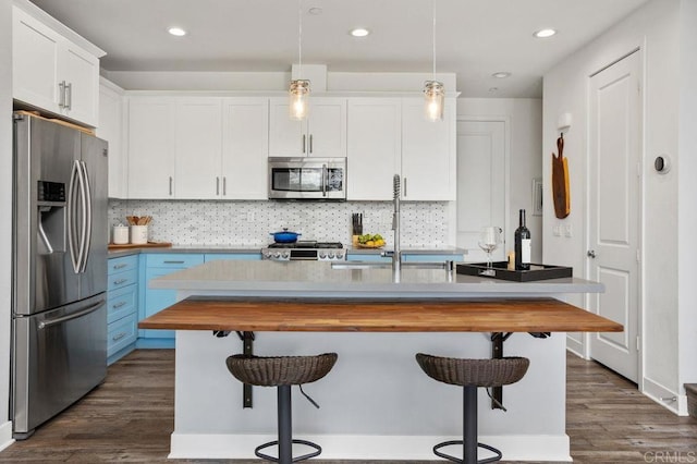 kitchen featuring dark wood-style floors, stainless steel appliances, white cabinets, a sink, and wood counters