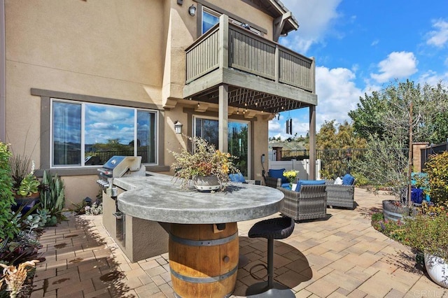 view of patio / terrace with an outdoor kitchen, a fenced backyard, a balcony, area for grilling, and outdoor dry bar