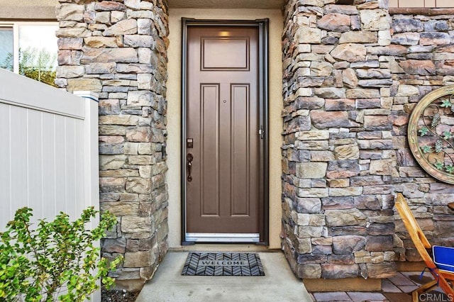 property entrance featuring stone siding