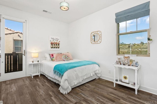 bedroom featuring visible vents, baseboards, and wood finished floors